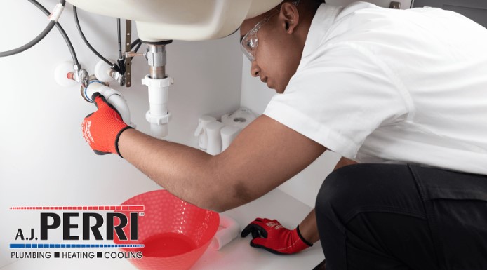 A.J. Perri plumber in Monmouth County, NJ, home fixing under-sink plumbing.