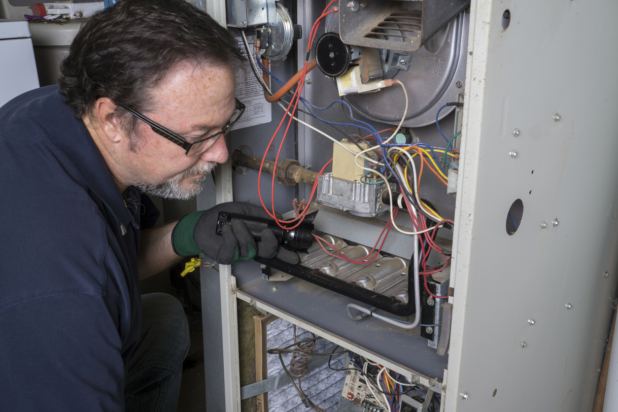 Air Experts technician providing heating service on a furnace in a New Jersey home.