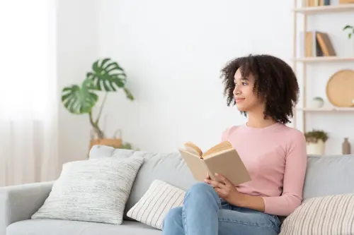 Woman feels relaxed and enjoys breathing fresh air in a cozy interior in a modern living room.
